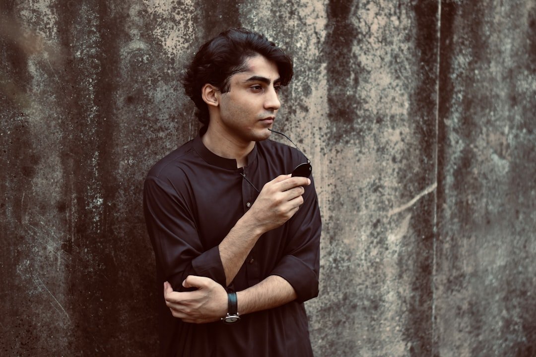 Boys best dresses in Pakistan - a man standing in front of a concrete wall