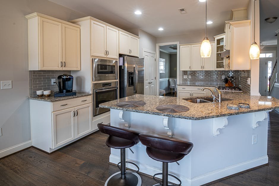 Spacious modern kitchen featuring a granite island and stainless steel appliances.